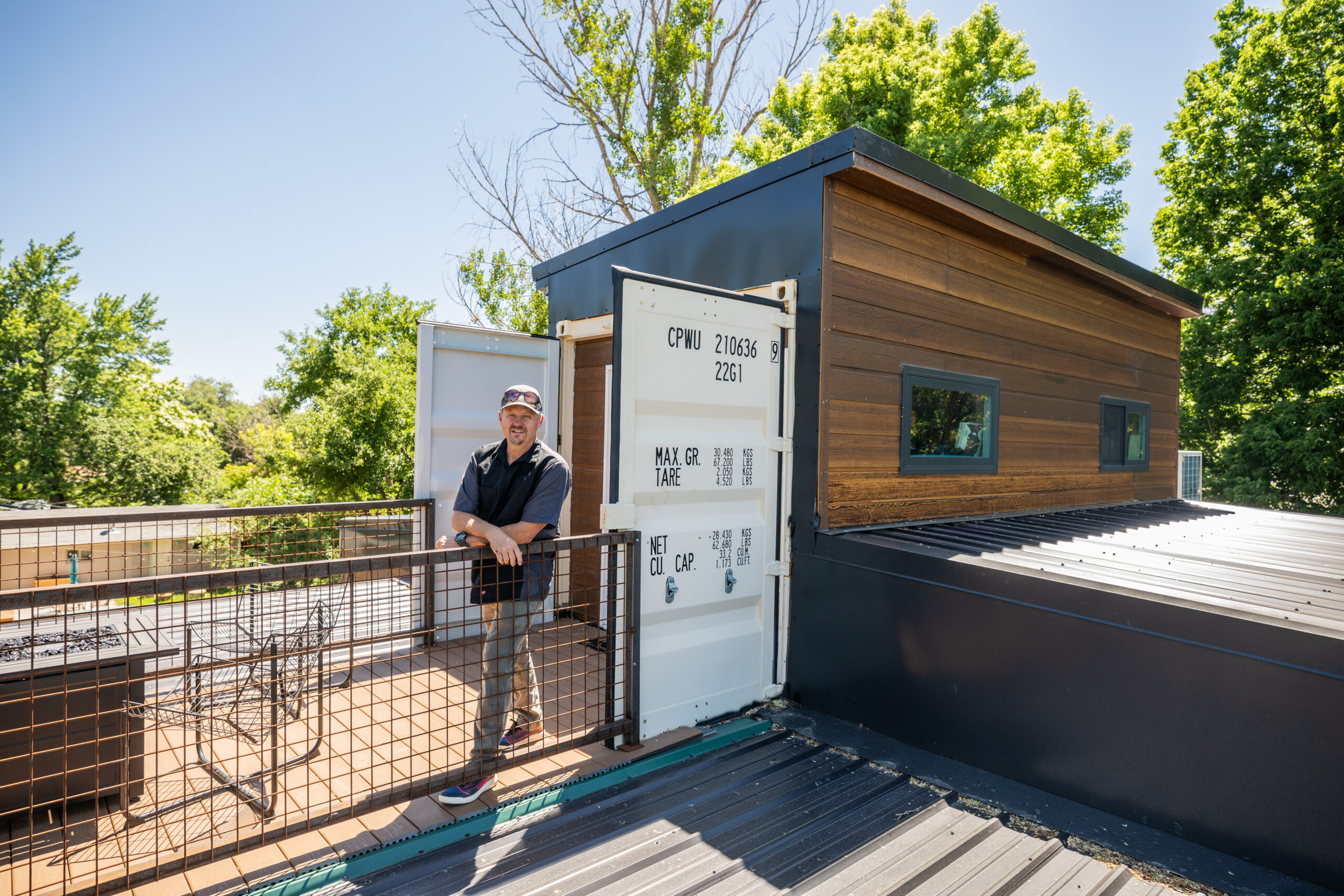 Shane standing on the deck beside a finished Carbon Dwell.