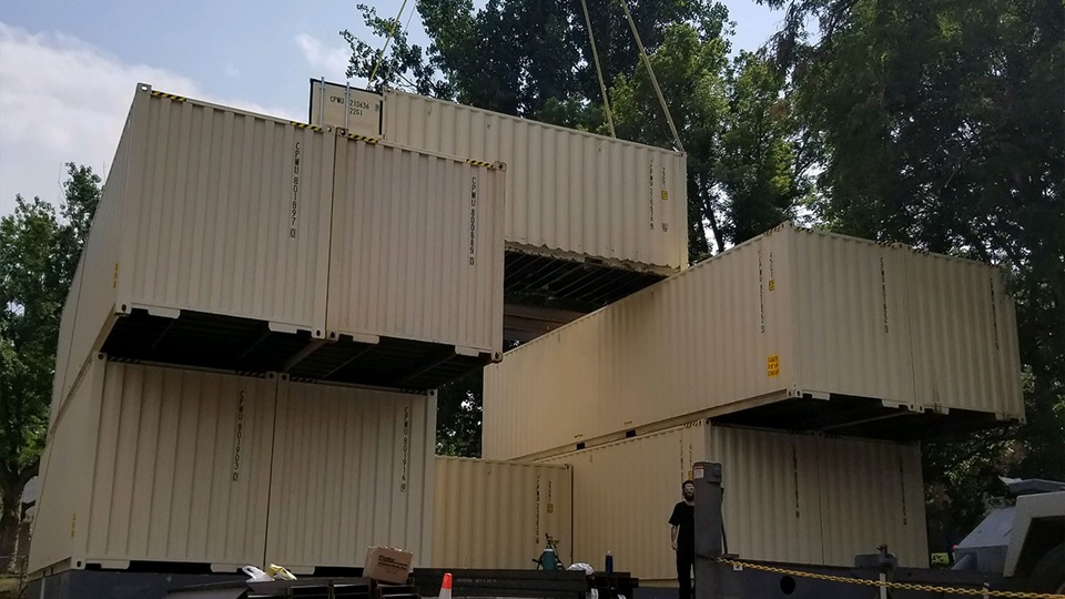 Shipping containers stacked into the frame of a new dwelling.