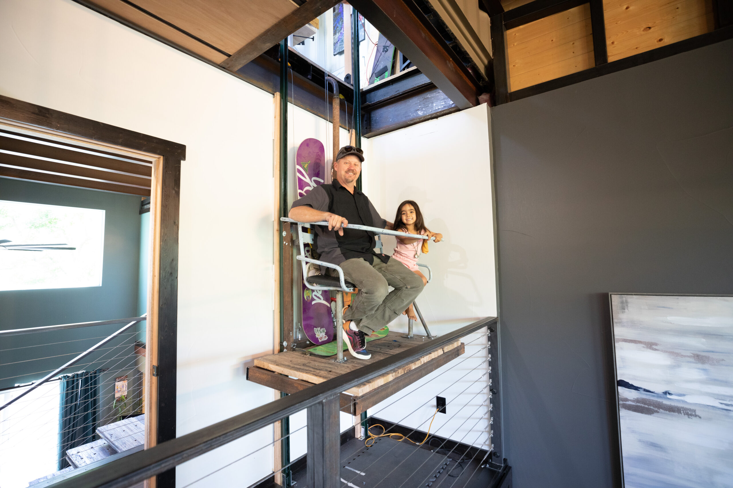 Two craftspeople working from a rolling scaffold inside a Carbon Dwell.