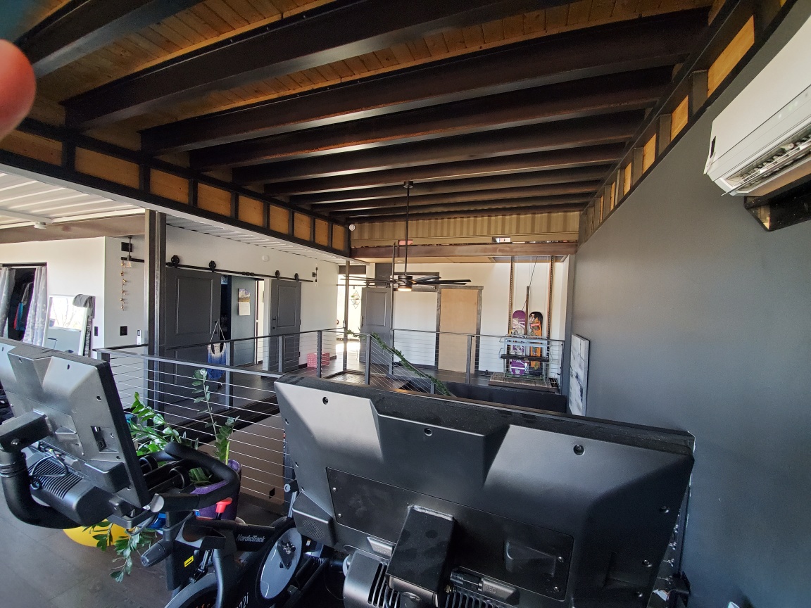 An upper-level workshop beneath exposed steel ceiling beams.