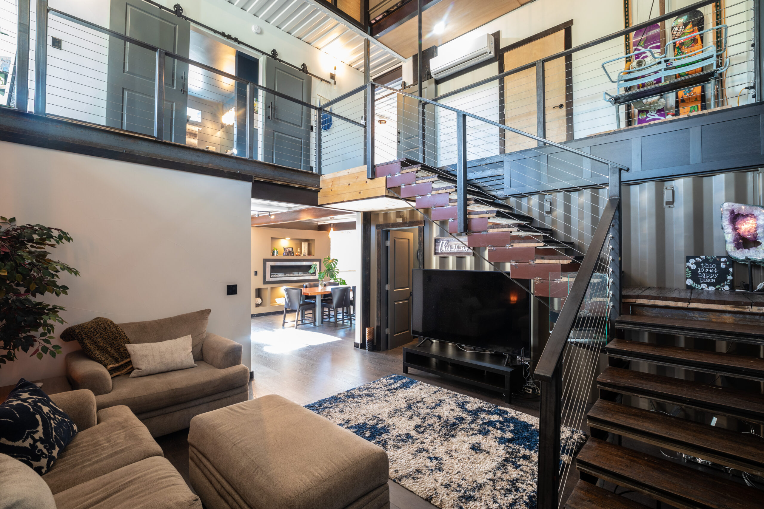 A finished Carbon Dwell living room with an exposed steel staircase.